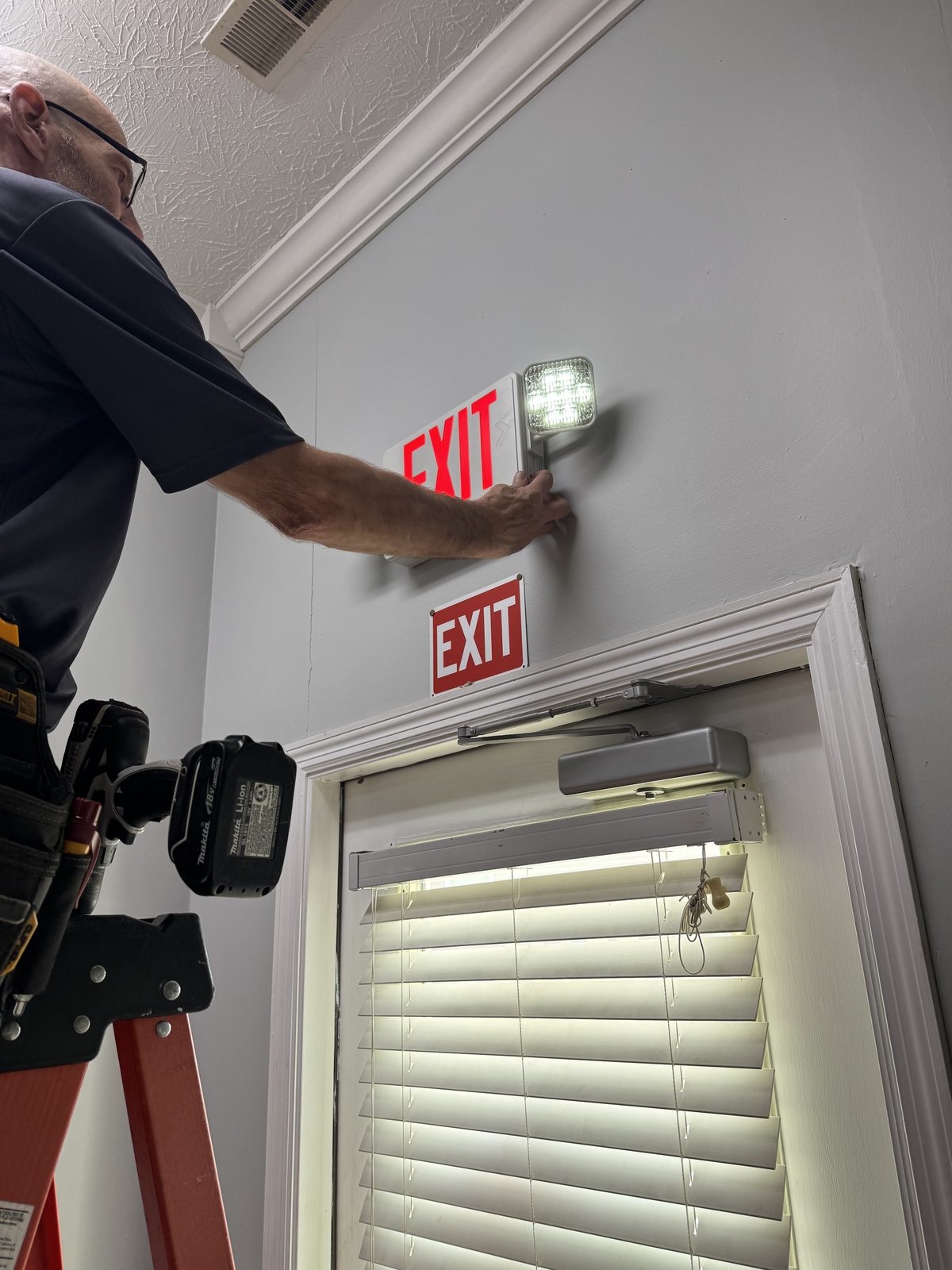 LED exit sign with battery backup emergency lights installed